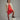 #color_spicy orange | Girl wearing a fine corduroy dress in bright orange hues with socks and a beige cardigan